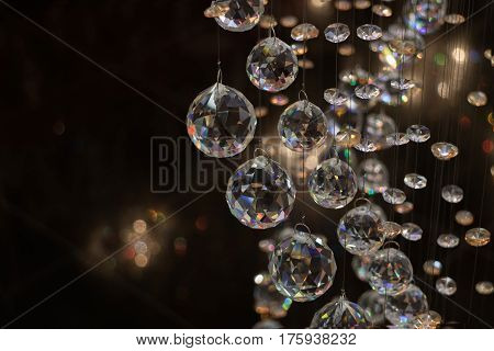 Beautiful crystal balls hanging on fine threads beautifully reflect. Cristall sphere in the dark