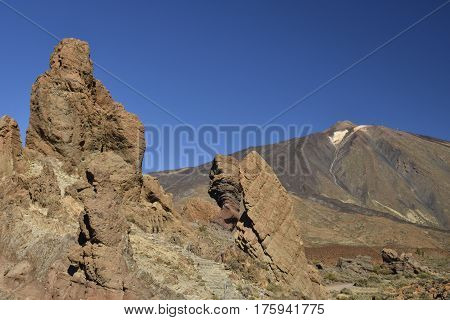Teide volcano from the East with lava stone formations in foreground and against a blue sky picture from Tenerife Spain.
