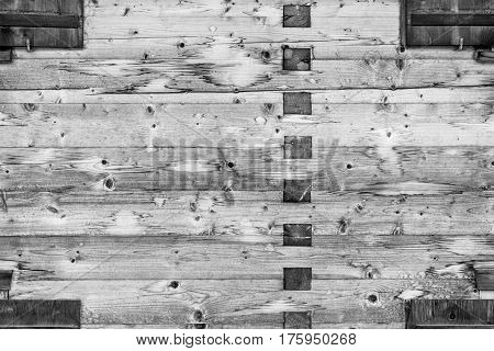 Modern Natural Log Cabin Wall Facade Frame Texture. Rustic Log Wall Square Timber Background. Fragment Of Barn Or House Wall From Unpainted Wooden planks Wallpaper. Monochrome.