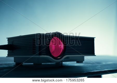 Mini Led Projector On Table In Dark Blude Tone Projector Home Theater Background.