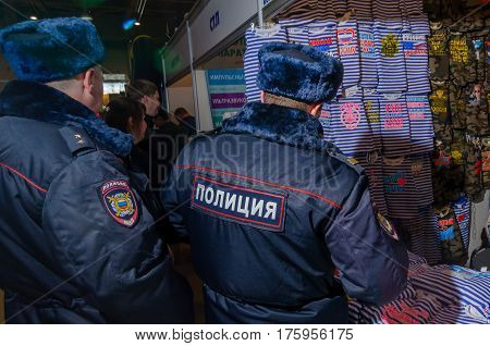 Moscow, Russia - February 25, 2017: Two russian policemen visiting the stand with funny military-patriotic t-shirts and telnyashkas