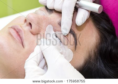 Woman on the procedure for eyelash extensions, eyelashes lamination