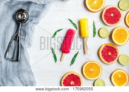 fresh citrus slices with fruit popsicles on stone table background top view