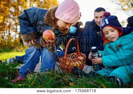 Girl Sitting On The Grass With An Apple In His Hand