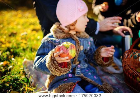 Girl Sitting On The Grass With An Apple In His Hand