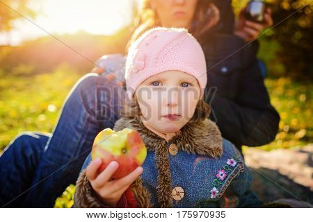 Girl Sitting On The Grass With An Apple In His Hand