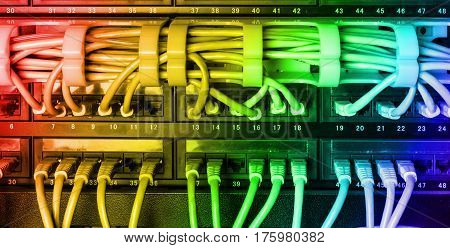 Server rack with colorful internet patch cord cables connected to black patch panel in server room horizontal with rainbow gradient