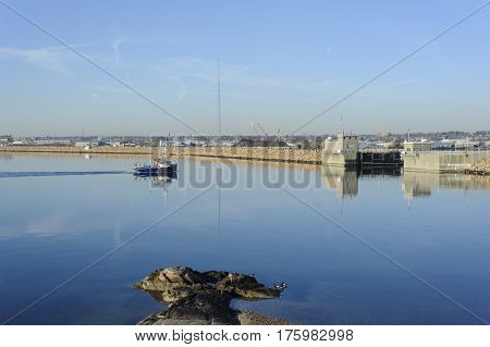 Fairhaven Massachusetts USA - January 16 2017: Fishing boat approaching entrance to New Bedford's inner harbor on windless morning