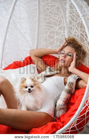Beautiful girl sexy blonde in lingerie posing in the bathroom with the dog