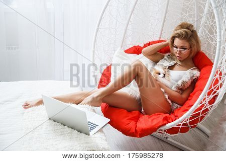 Beautiful girl sexy blonde in lingerie posing in the bathroom with the dog