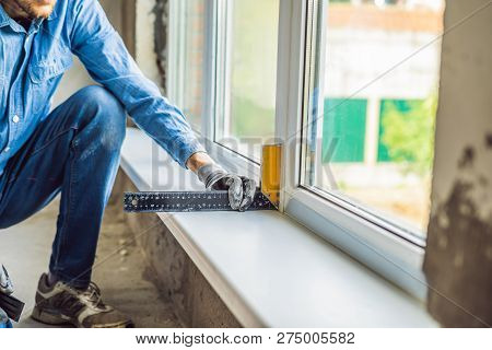 Man In A Blue Shirt Does Window Installation