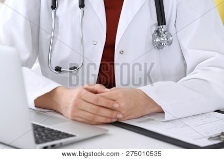 Close-up Of A Unknown Female Doctors Hands. Physician At Working Place Ready To Consult And Halp Pat