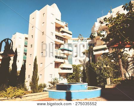Residential Buildings And Fountain Surrounded With Green Plants In  Rishon Le Zion.
