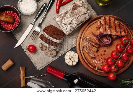 Sliced Grilled Pork Steaks With Bottle Of Wine, Wine Glass, Corkscrew, Knife, Fork, Black Bread, Che