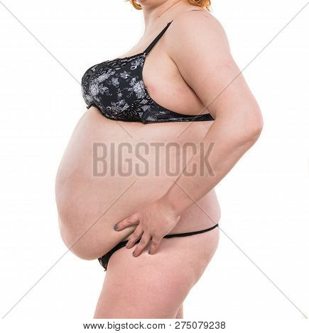 Healthcare, Medical And Overweight Concept. Overweight Woman Measuring Her Fat Belly On A White Back