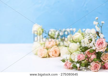 Border From Fresh White Gypsofila And White Rose Flowers On Against Blue Textured Background.  Place
