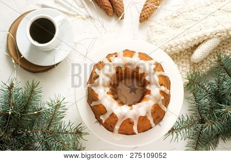 Pie With Raisins And Icing From Powdered Sugar On The Background Of Fir Branches And Garlands. Rusti