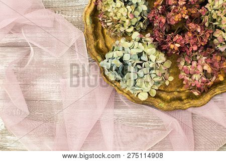Vintage Tray With Dried Blue Hydrangea Flowers On A Purple Transparent Tulle Fabric On A Gray Table.
