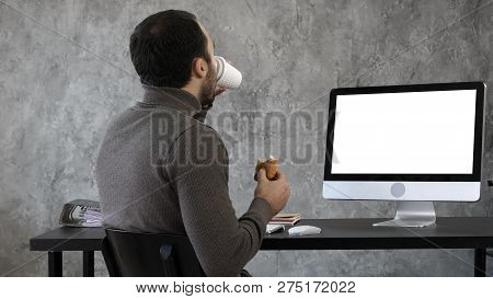Business Man In The Office Having Breakfast, Lunch And Watching Something On The Mac, Computer. Whit