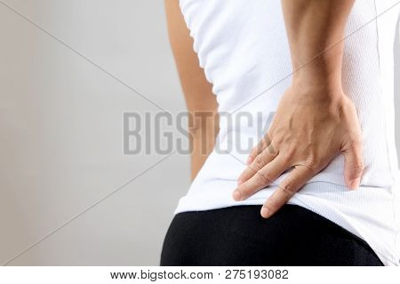 Young Woman Pain At Lower Back, Woman Holding Hand On Lower Back Muscle Area With Pain Action