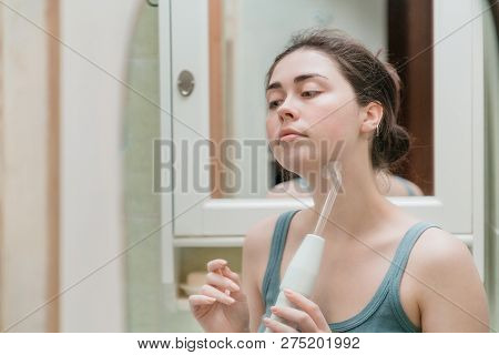 A Young Girl Takes Care Of The Skin Of The Face Making Procedures Using The Darsonval Device While I