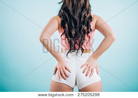 Beautiful Twerk Woman In White Jeans Shorts On Blue Background, Rear View, From Behind. Sexual Brune