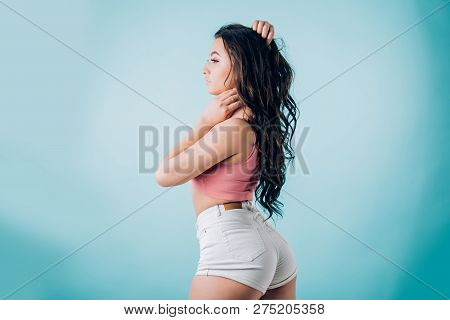 Beautiful Pumped Fitness And Dancing Brunette Woman In Short White Shorts And Pink Top On Blue Backg