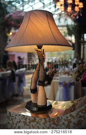 Beautiful Table Lamp In The Form Of Female Legs In Stockings Is Included In The Room
