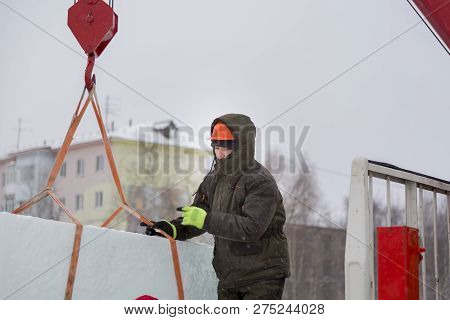 Portrait Of A Fitter Slinger In A Jacket And Helmet On The Unloading Of Ice Plates