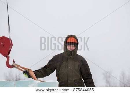 Portrait Of A Fitter Slinger In A Jacket And Helmet On The Unloading Of Ice Plates