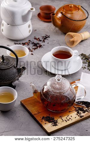 Tea Card. Different In Appearance Teapots On A Gray Background, Different Types Of Tea. Assortment.