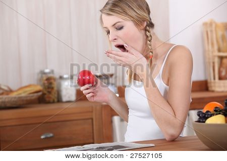Jeune femme bâillements au petit-déjeuner