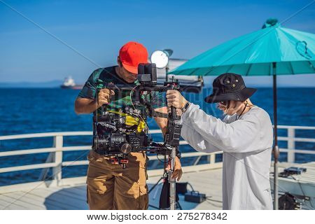 Steadicam Operator And His Assistant Prepare Camera And 3-axis Stabilizer-gimbal For A Commercial Sh