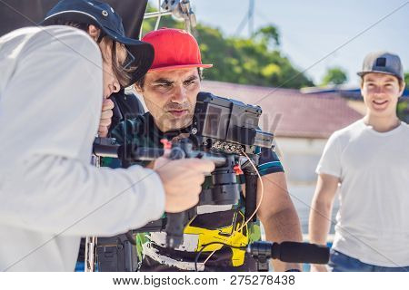 Steadicam Operator And His Assistant Prepare Camera And 3-axis Stabilizer-gimbal For A Commercial Sh