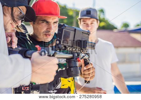 Steadicam Operator And His Assistant Prepare Camera And 3-axis Stabilizer-gimbal For A Commercial Sh