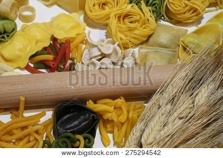 Kitchen Rolling Pin With A Lot Of Fresh Italian Pasta And Wheat Ears. The Big Black Raviolo Is Made 
