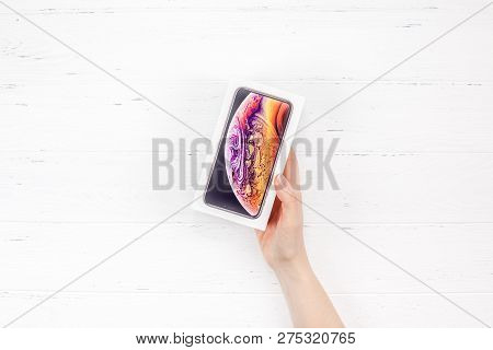 Berlin, Germany - December 09, 2018: Woman Hands Holding The Colorful Box Of The Latest Apple Iphone