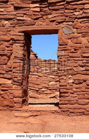 alte Schlamm-Mauer und Eingang bauen mit roten Felsen in Wupatki pueblo