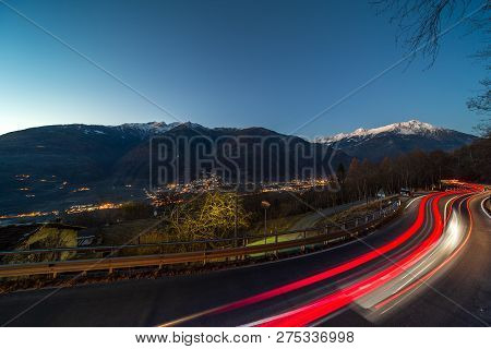 Lightstrails Of Vehicles In Movement For A Road In The Moonlight Motta, Italy.