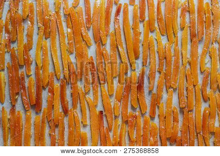 Candied Orange Peel, Cooked In Sugar Syrup With Vanilla And Ginger, Drying On Parchment.