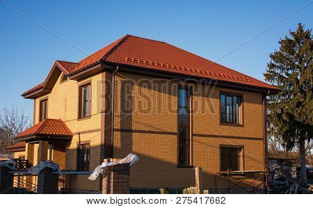 Two-storey Brick House With Tall Narrow Vertical Window, Rectangular Windows, Snow Guards And Rain G