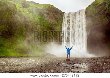 Single Man Standing Near Scogafoss Waterfall In Iceland And Spread His Hands. Travel Summer Nordic C