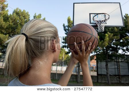 Jeune femme prête à jeter de basket-ball dans la boucle