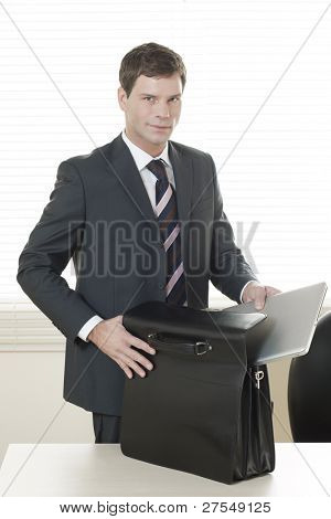 Businessman in his office with briefcase