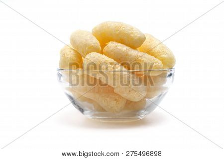 Yellow Corn Puffs In A Glass Bowl Isolated On White Background. Crunchy Flavored Puffed Snacks. Part