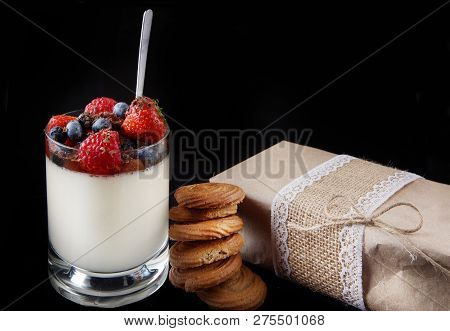 Panakota Creamy Italian Dessert In A Glass Cup With Berries, Next To A Stack Of Ginger Cookies And A