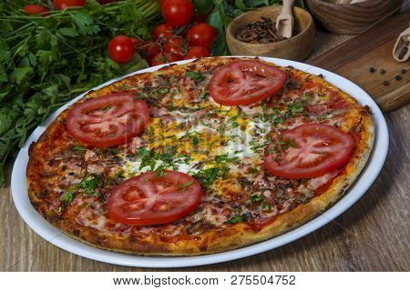 Pizza With Bacon, Paprika And Arugula. Italian Cuisine. On A Wooden Background. Free Space For Text.