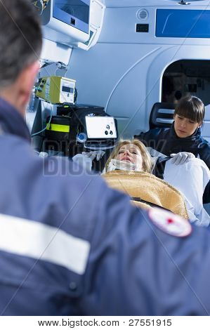 Einnahme von Frau auf trage in den Krankenwagen Sanitäter