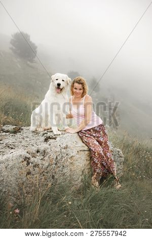 Beautiful Women And Two White Dogs Morema Sit On Rock In Fog