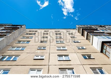Bottom-up View Of The Multi-storey Building, Blue Sky And Light Clouds Above The House